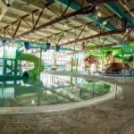 Indoor water park featuring colorful slides, play structures, and a large pool.