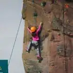 child on apex center rock climbing wall