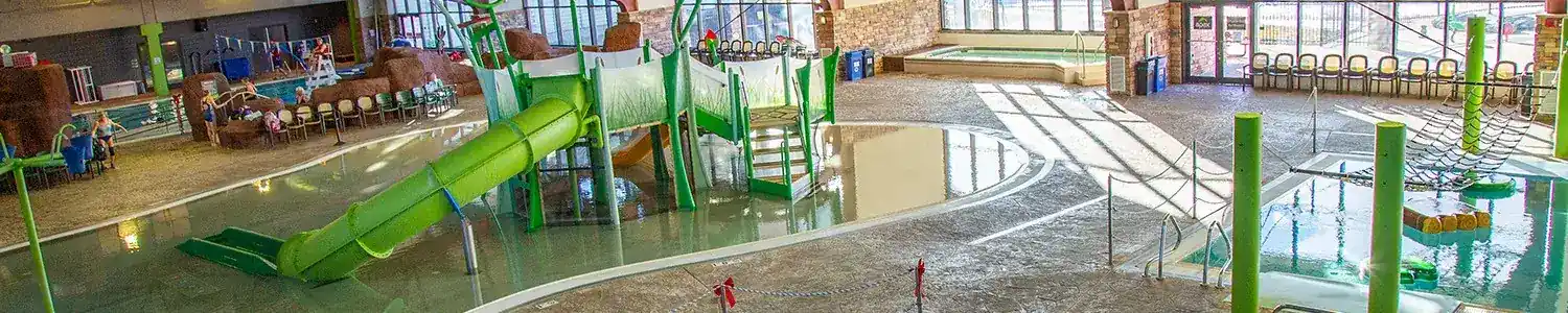 Indoor water park featuring a green slide.
