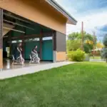 Two people on exercise bikes outside of a building.