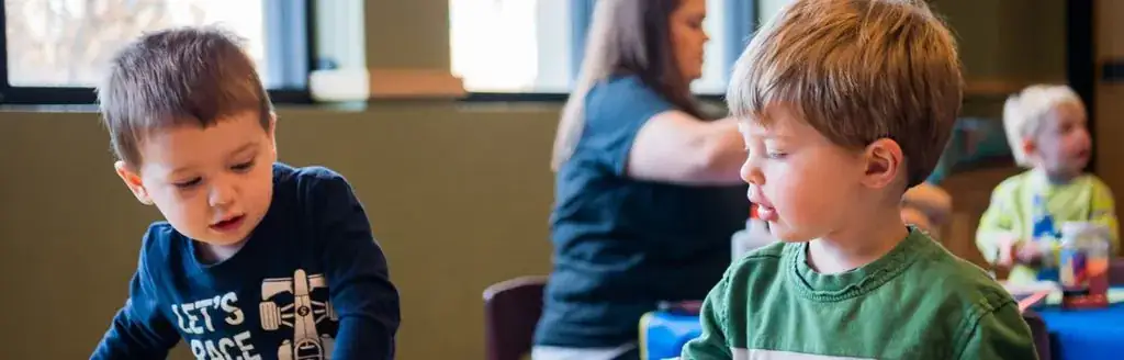 A couple of kids sitting at a table.
