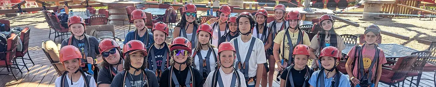 A group of individuals wearing red helmets and harnesses.