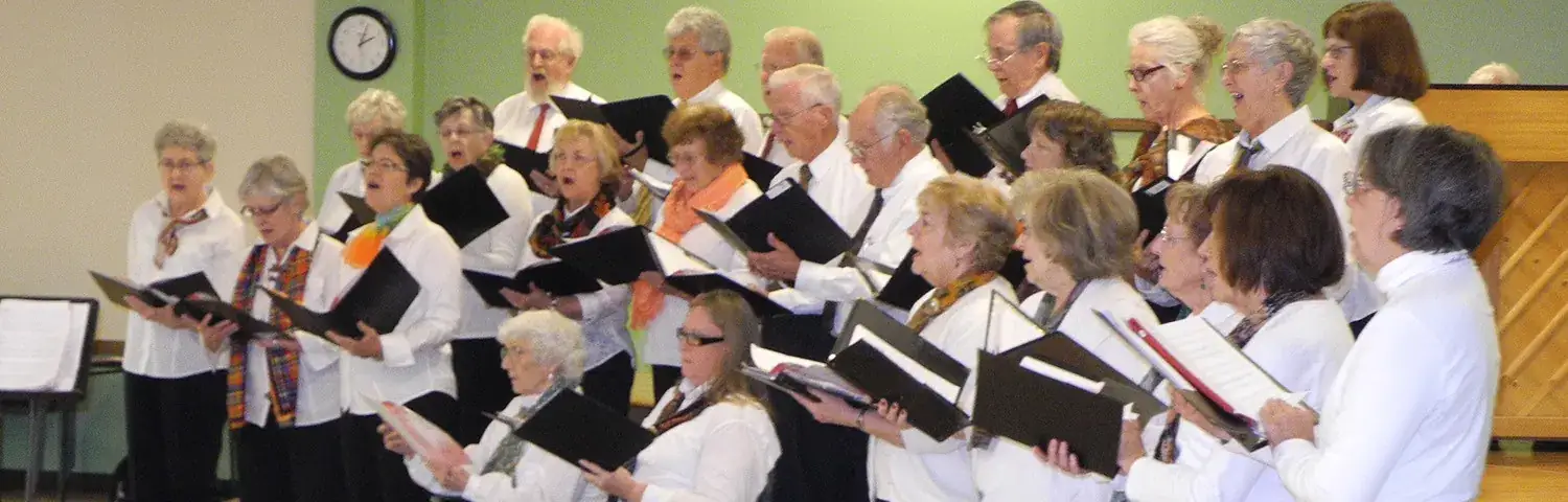 A diverse group of choir members in white shirts.