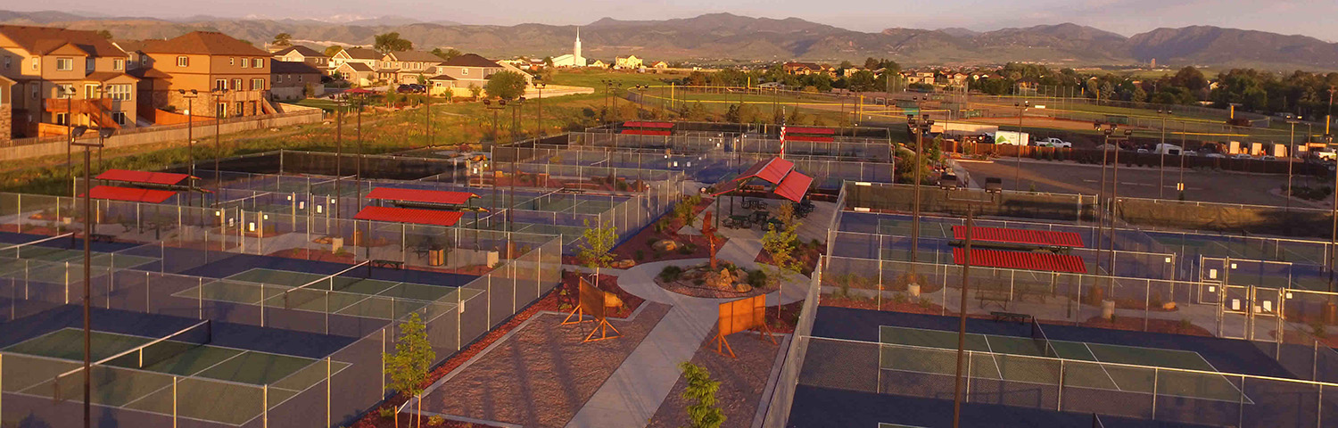 Aerial view of a sports complex with multiple fenced pickleball courts.