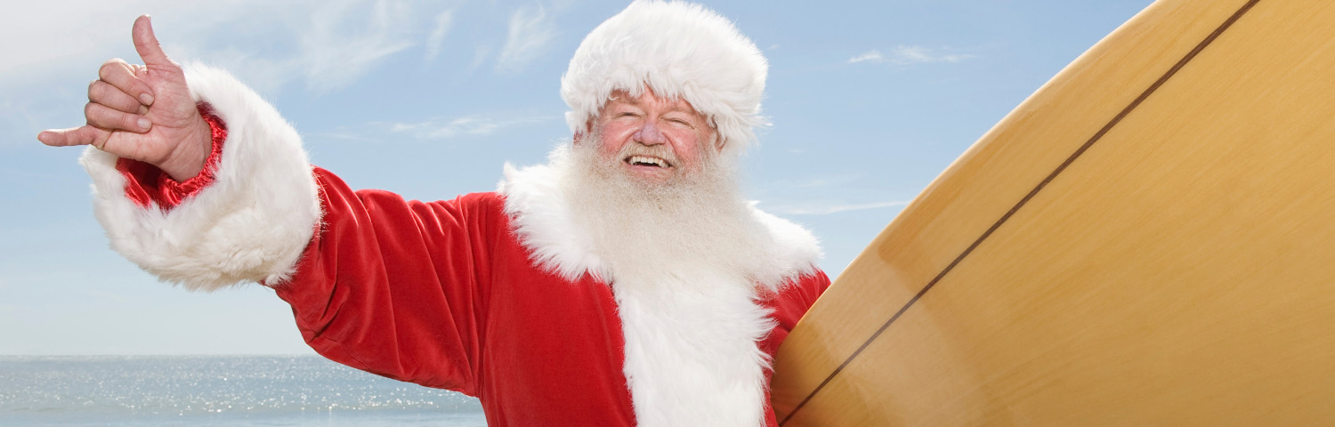Santa Claus Gesturing With Surf Board On Beach